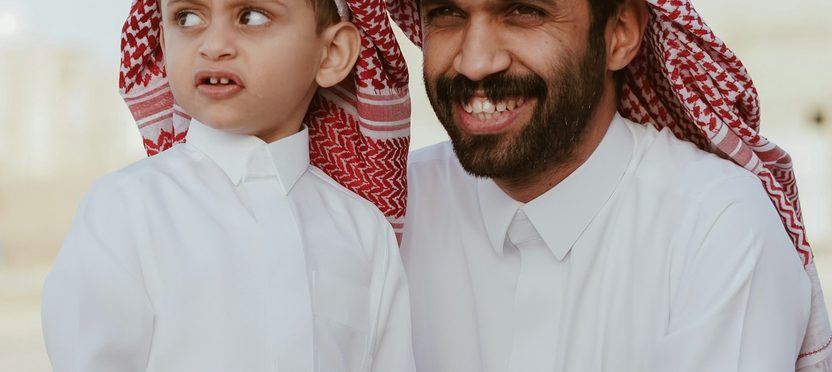 A Gulf father and son in kandura and ghutra