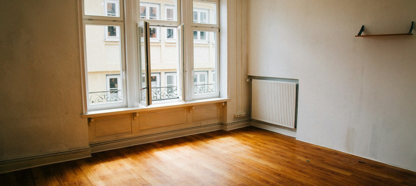 A finished, empty apartment with warm light on a wooden floor